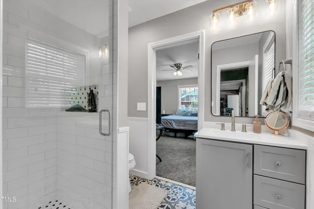 a en suite bathroom with a granite countertop sink and a mirror