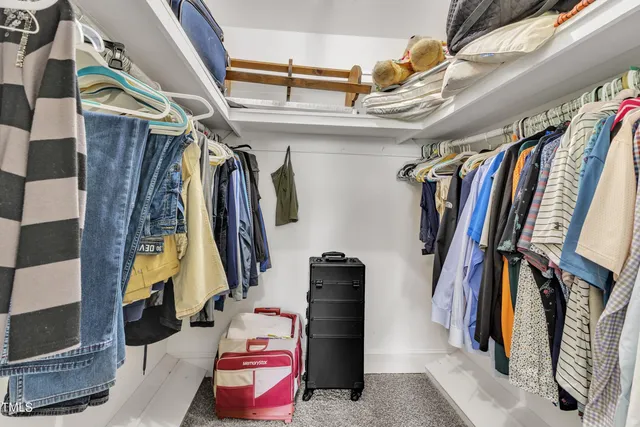a view of walk in closet with clothes and shoes