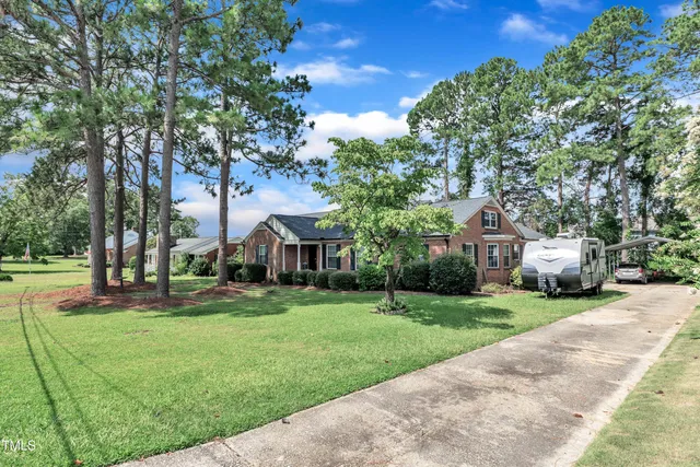 a front view of a house with a yard and trees