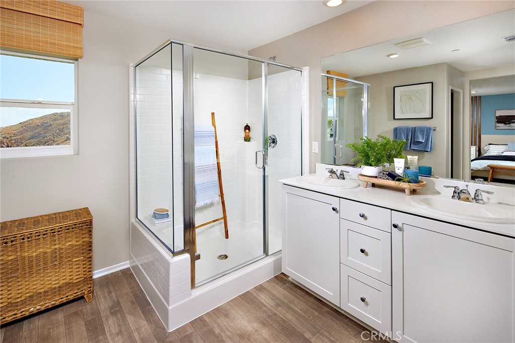 30607 Cyclone Avenue Winchester, CA 92596 - Photo 13 of 18 a bathroom with a double vanity sink a mirror and a shower