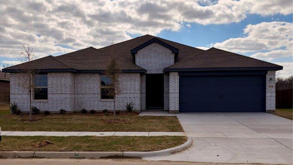 Ranch-style home with an attached garage, brick siding, driveway, and a front yard