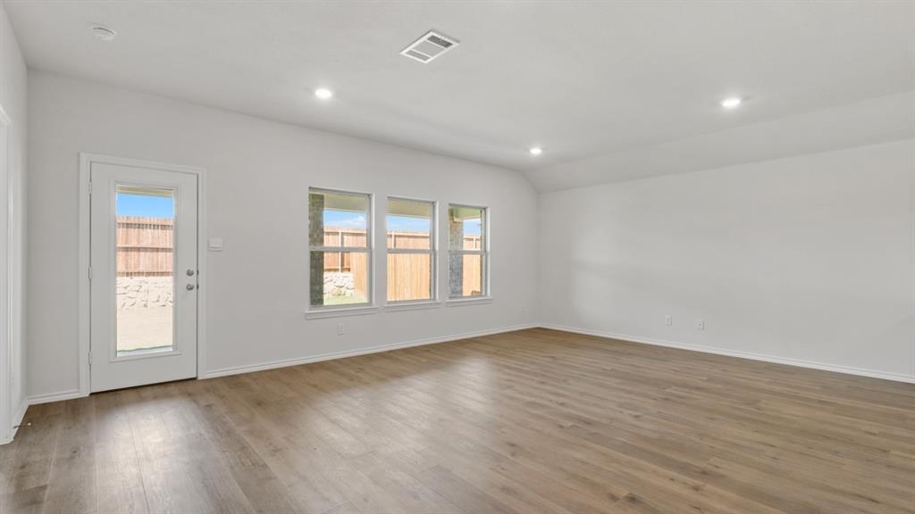 1913 Reveille Way Terrell, TX 75160 - Photo 10 of 27 Empty room featuring lofted ceiling, dark wood-type flooring, and recessed lighting