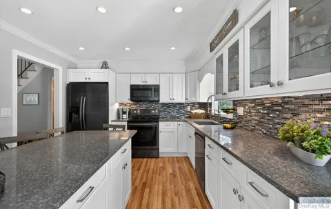 a modern kitchen with stainless steel appliances granite countertop a sink stove and refrigerator
