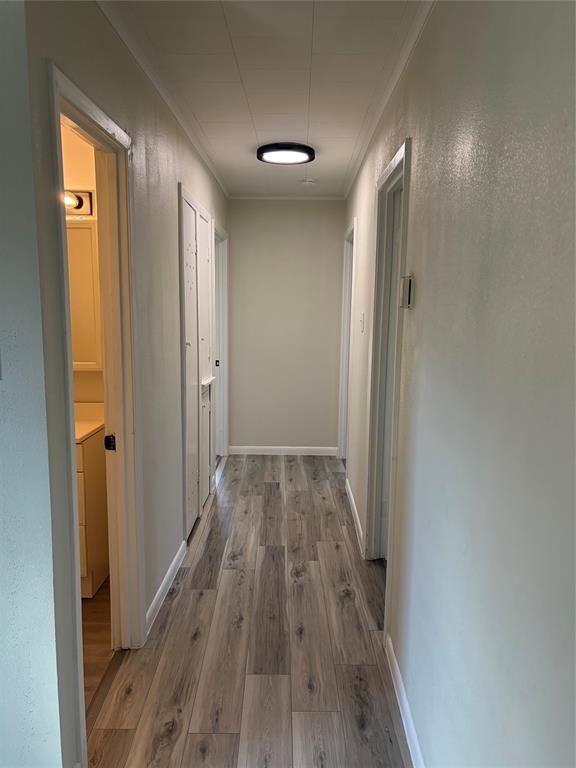 2293 County Road Powderly, TX 75473 - Photo 17 of 20 a view of a hallway with wooden floor and a bathroom