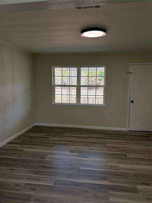 2293 County Road Powderly, TX 75473 - Photo 3 of 20 a view of an empty room with wooden floor and a window