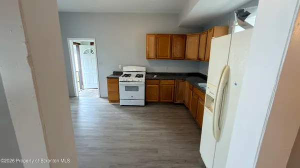 a kitchen with stainless steel appliances granite countertop a refrigerator a stove top oven a sink and dishwasher