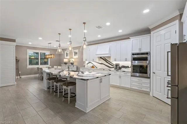 a open kitchen with stainless steel appliances granite countertop a sink a stove and a refrigerator