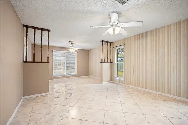 an empty room with fan and windows