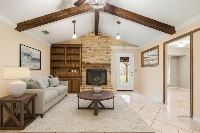 a living room with furniture a fireplace and a chandelier