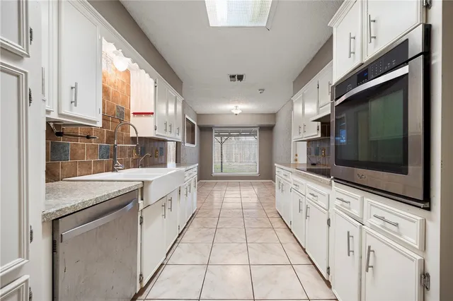 a large kitchen with granite countertop a sink and a stove top oven