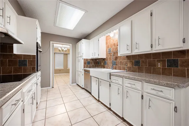 a kitchen with granite countertop white cabinets and white appliances