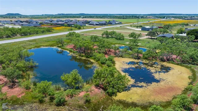 an aerial view of ocean and residential houses with outdoor space