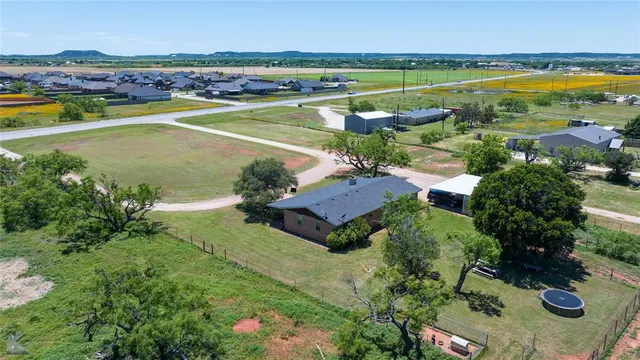 an aerial view of a house with a garden and lake view