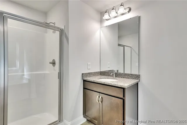 a bathroom with a granite countertop sink a mirror and a shower
