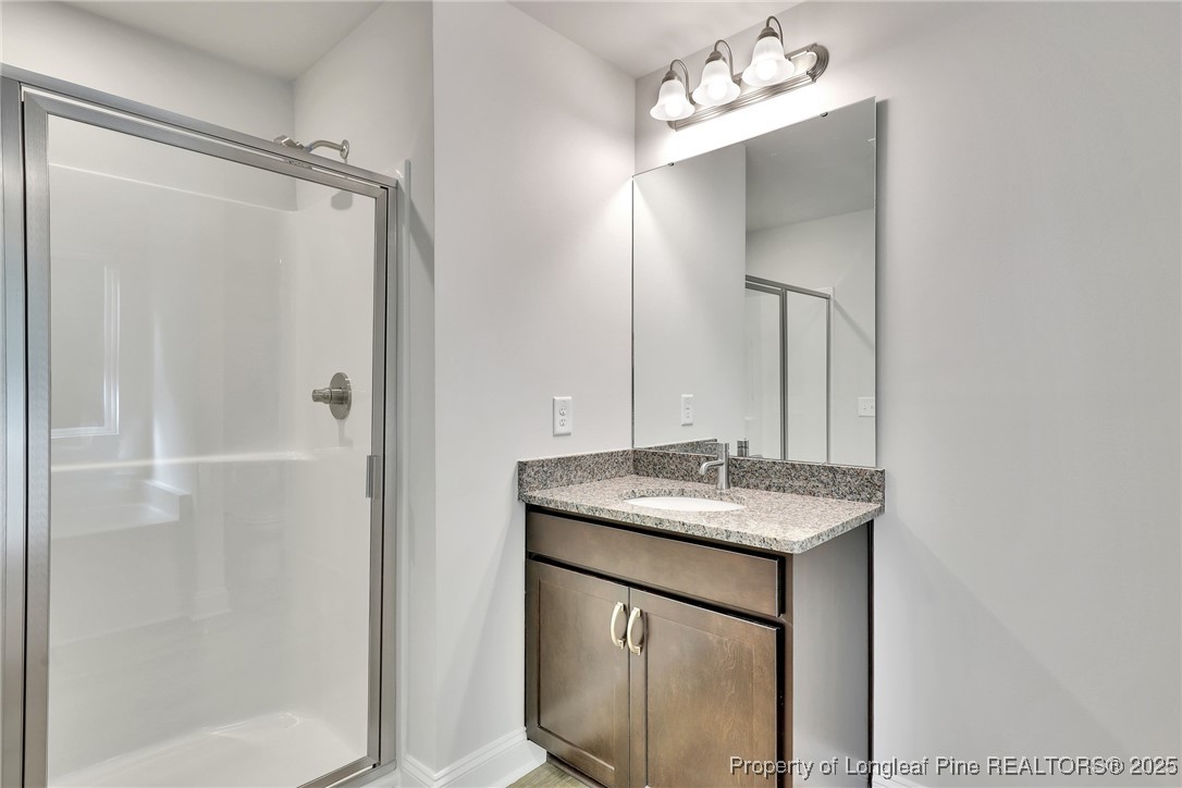 1036 Meadow Reach Sanford, NC 27332 - Photo 11 of 30 a bathroom with a granite countertop sink a mirror and a shower