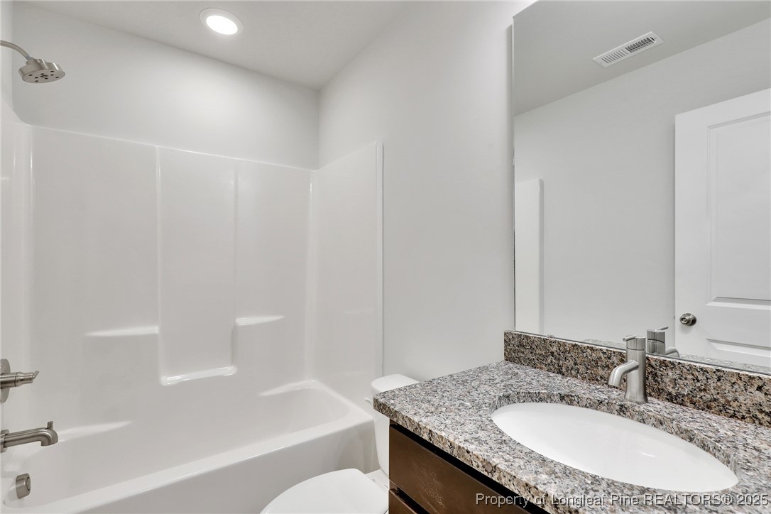 1036 Meadow Reach Sanford, NC 27332 - Photo 17 of 30 a bathroom with a granite countertop sink toilet and bathtub