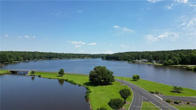 a view of a lake with a yard and outdoor seating