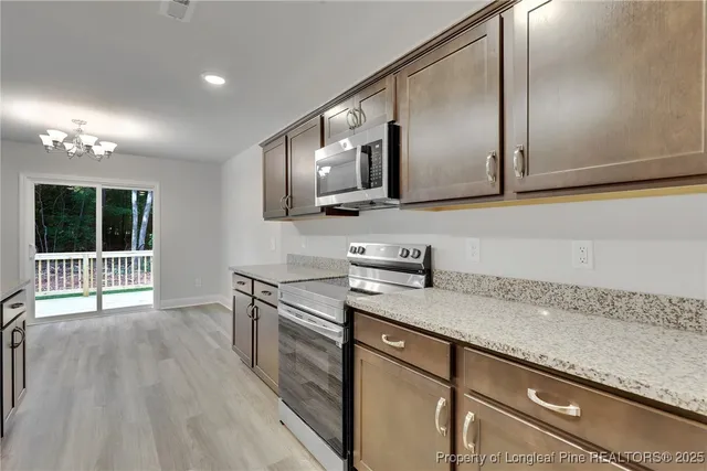 a kitchen with granite countertop a sink a stove and cabinets