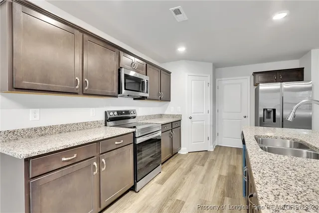 a kitchen with stainless steel appliances granite countertop a sink stove and oven