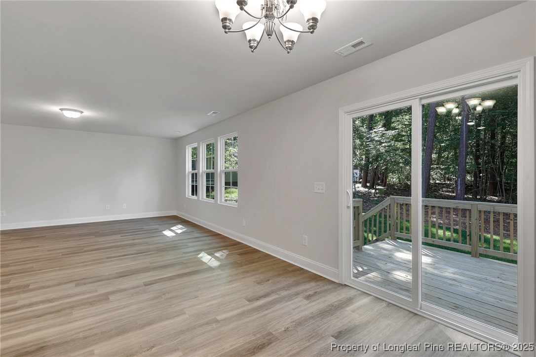1036 Meadow Reach Sanford, NC 27332 - Photo 8 of 30 a view of an empty room with wooden floor and a window