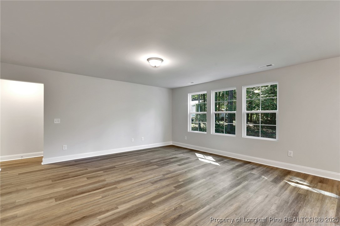 1036 Meadow Reach Sanford, NC 27332 - Photo 9 of 30 a view of an empty room with wooden floor and a window