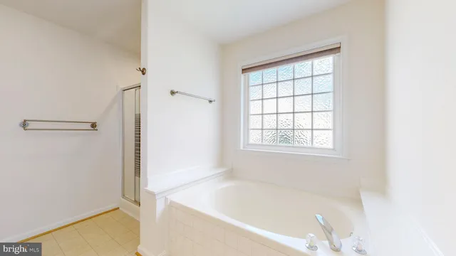 an empty room with chandelier fan and windows