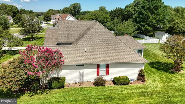 an aerial view of residential houses with outdoor space and trees