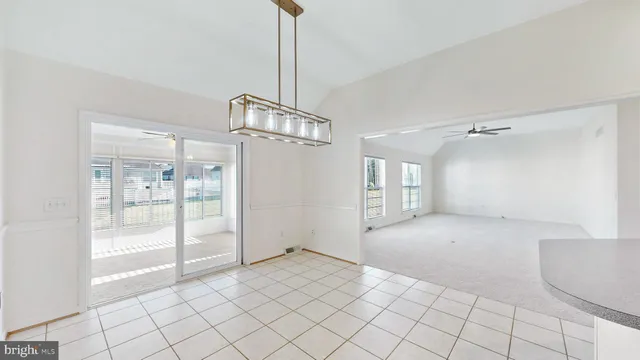 an empty room with windows and ceiling fan