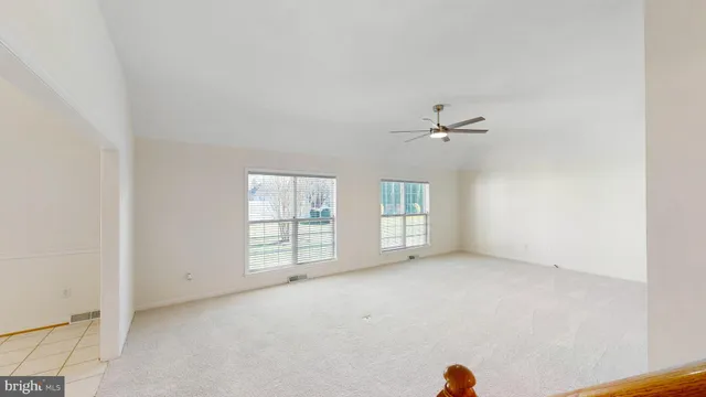 an empty room with a ceiling fan and window