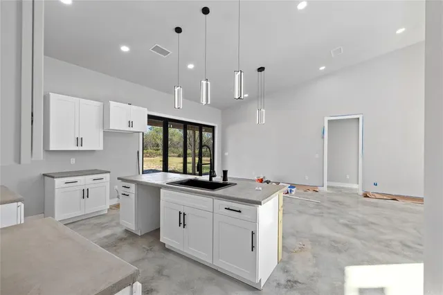 a kitchen with granite countertop a sink and white cabinets