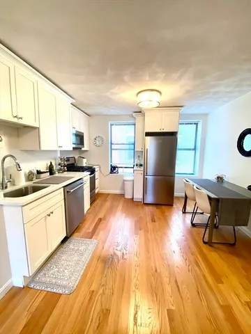 a kitchen with a wooden floor and a refrigerator