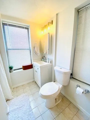 a white toilet sitting next to a bathroom sink and a tub