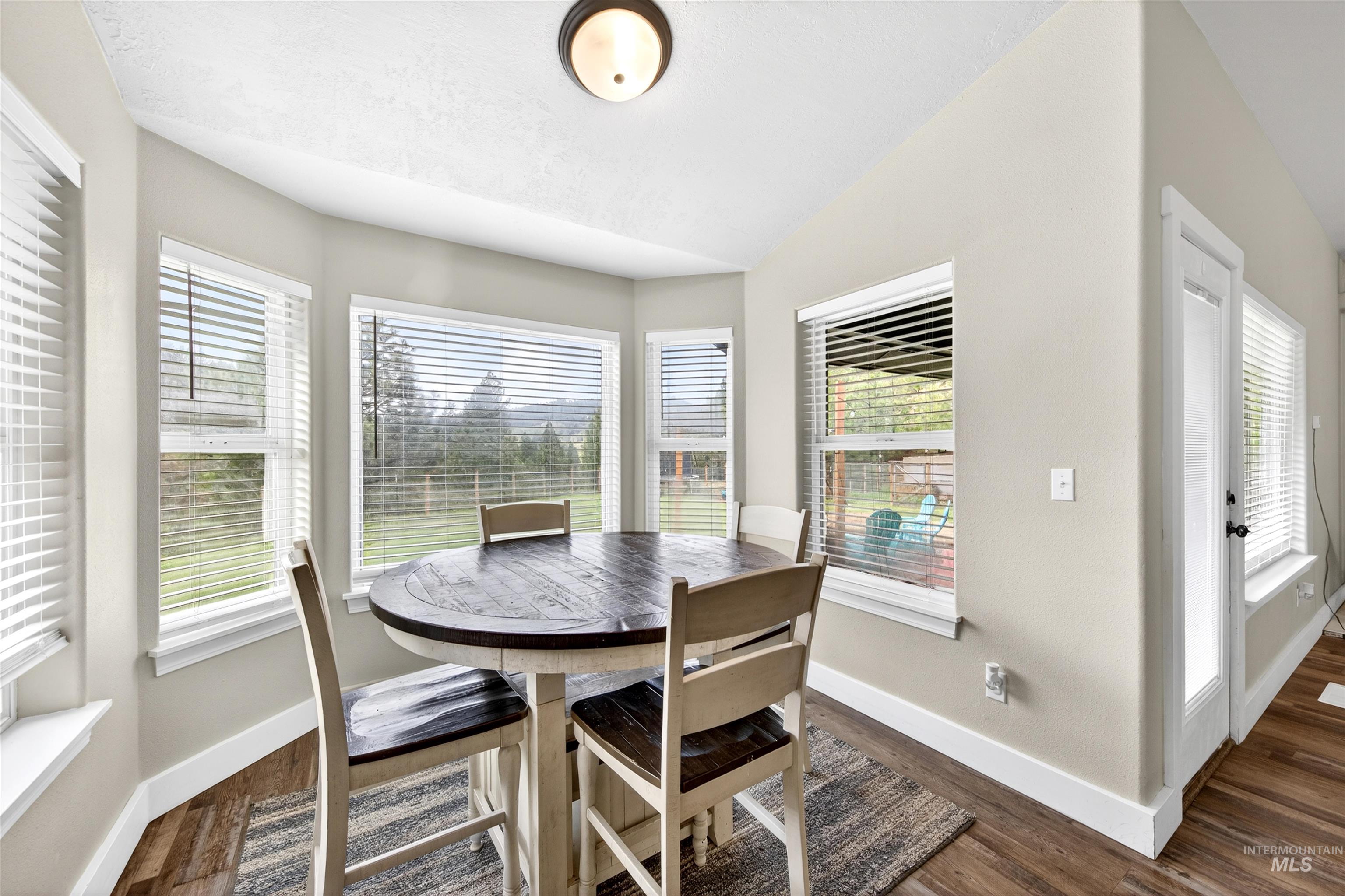 4 Round Up Circle Boise, ID 83716 - Photo 12 of 47 Bright dining area featuring a bay window design, wood-finish flooring, and a ceiling-mounted light fixture