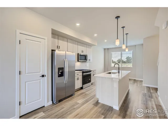 a kitchen with stainless steel appliances a refrigerator and a stove top oven