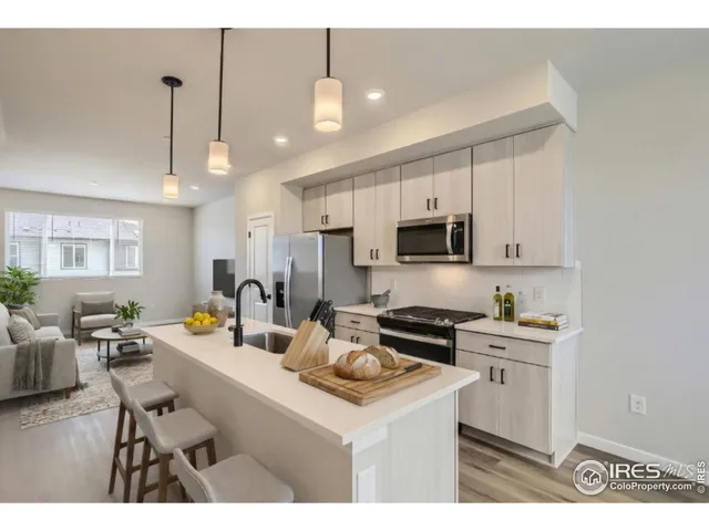 a kitchen with stainless steel appliances a stove a sink a microwave a refrigerator and cabinets