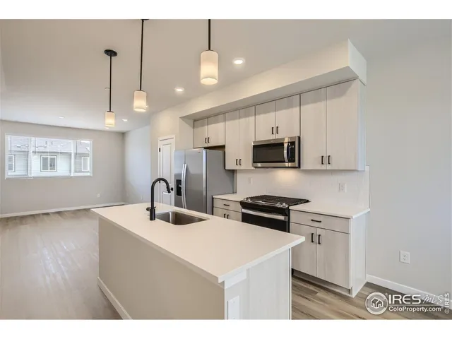 a kitchen with stainless steel appliances a sink stove and refrigerator