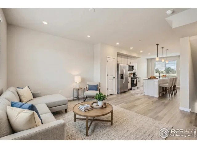 a view of a kitchen with a refrigerator white cabinets and wooden floor