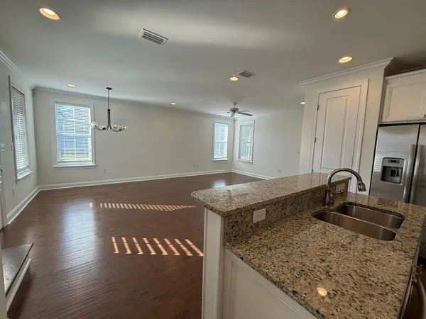 a kitchen with granite countertop a sink a counter top space and cabinets