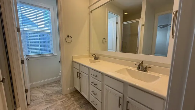 a bathroom with double sink and a mirror