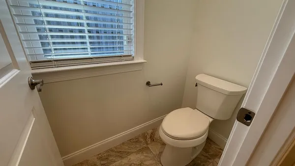 a white toilet sitting next to a window