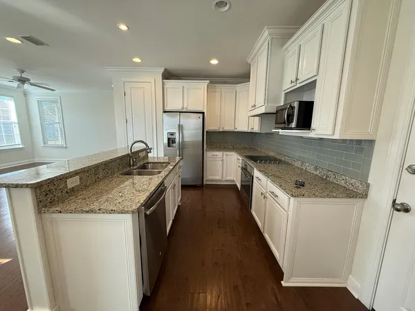 a kitchen with stainless steel appliances granite countertop a sink stove and refrigerator