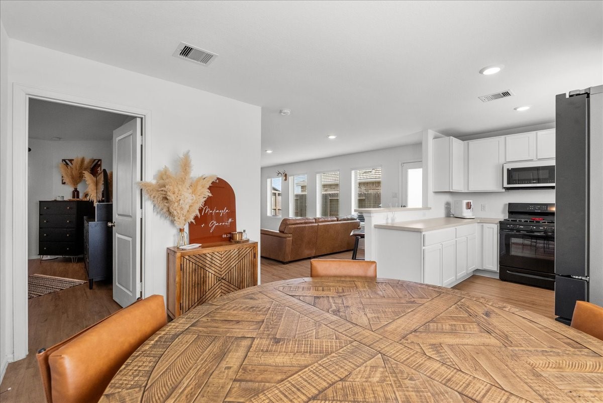 14410 Boyton Holw Trace Rosharon, TX 77583 - Photo 18 of 35 View from Dining area towards Primary Bedroom on the left and Kitchen/Living Room showcasing how each area has its zone and allows for a great common space. Great flow of space!