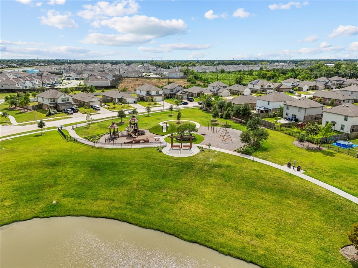 14410 Boyton Holw Trace Rosharon, TX 77583 - Photo 32 of 35 This Amenity is a Community Park, Playground & features a Pergola Sitting area near the lake. It is located across the lake and shows the trail behind the home connecting through the common space.