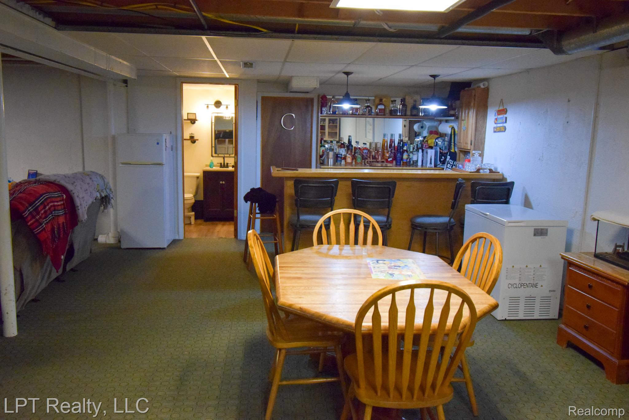 217 Nawakwa Road Rochester, MI 48307 - Photo 22 of 29 Carpeted basement dining area with bar and a paneled ceiling