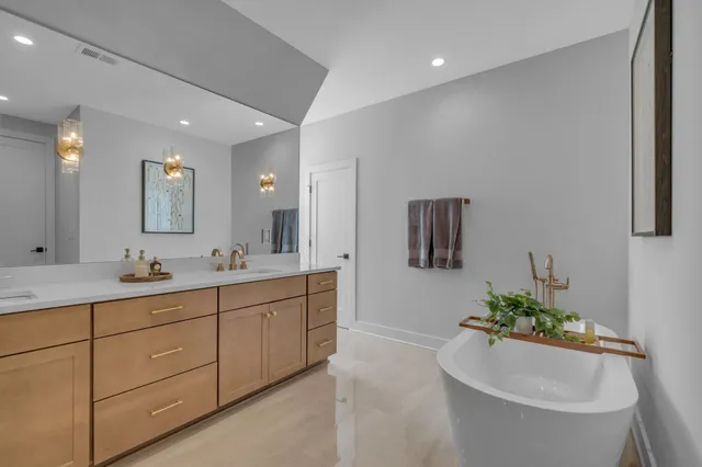 a bathroom with a toilet a sink a mirror a bathtub and vanity