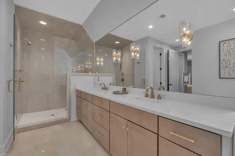 a bathroom with a sink shower and a mirror