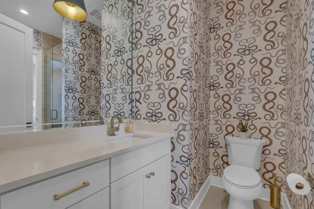 a bathroom with a granite countertop sink and a toilet