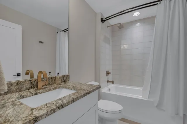 a bathroom with a granite countertop sink toilet and shower