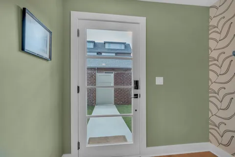 a view of a hallway with wooden floor and a bathroom