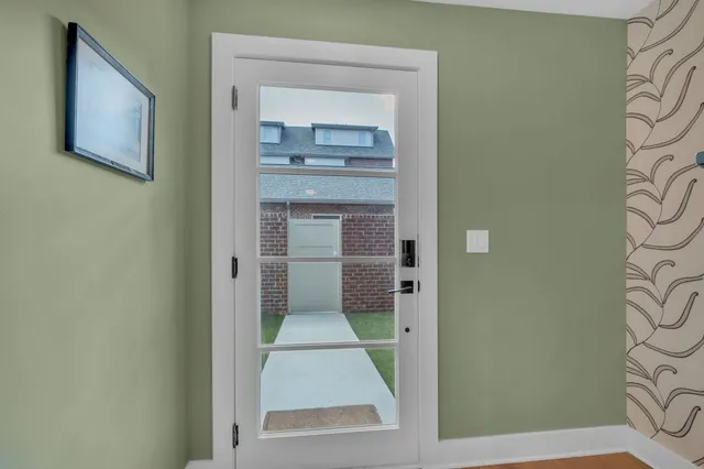 a view of a hallway with wooden floor and a bathroom
